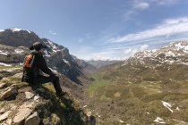 Homem olhando para a paisagem sentado no topo da montanha, Espanha, Astúrias, Somiedo — Fotografia de Stock