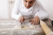 Chef cortando ravioles frescos - foto de stock