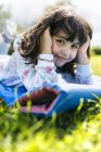 Portrait of smiling little girl lying on airbed on a meadow — Stock Photo