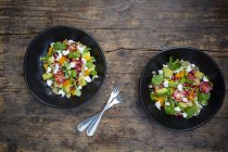 Salad bowls with lettuce, quinoa, yellow bell pepper, cocktail tomato, avocado, feta and pomegranate seeds — Stock Photo