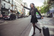 France, Paris, young woman hailing a taxi — Stock Photo