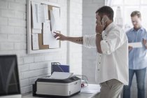Vista lateral do homem no escritório da cidade falando em um telefone — Fotografia de Stock