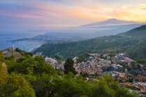 Italia, Sicilia, Taormina con el Monte Etna al atardecer - foto de stock