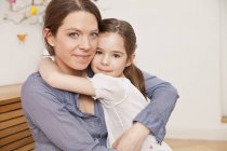 Ritratto di madre e figlia che si abbracciano a casa — Foto stock