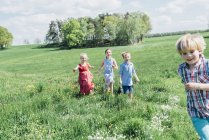 Children running and playing in meadow — Stock Photo