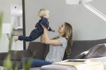 Mother and son at home playing on couch — Stock Photo