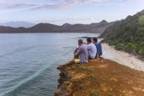 Indonesien, Insel Sumbawa, männliche Freunde sitzen auf einem Aussichtspunkt und unterhalten sich — Stockfoto