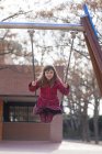 Portrait of smiling little girl on a swing — Stock Photo