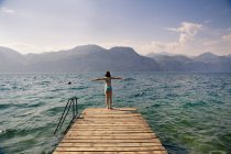 Италия, Бренцоне, вид сзади на девушку, стоящую на пристани — стоковое фото