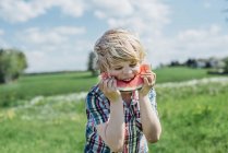 Garçon manger tranche de pastèque — Photo de stock