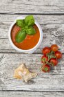 Tomato soup and tomatoes on wood — Stock Photo