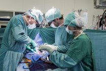 Cirurgiões cardíacos e enfermeira de centro cirúrgico durante uma operação — Fotografia de Stock