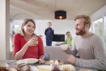 Parents prenant le petit déjeuner à la maison avec des enfants en arrière-plan — Photo de stock