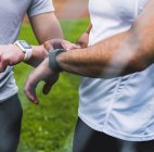 Close-up de dois atletas com smartwatches ao ar livre — Fotografia de Stock