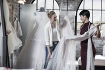 Brautkleid-Designerin und Braut stehen im Brautladen — Stockfoto