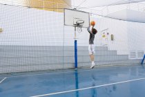 Young man playing basketball on a deck of a cruise ship — Stock Photo
