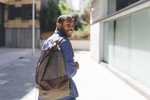 Sonriente hombre afro con mochila - foto de stock