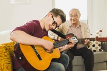Grandfather and grandson playing guitar together — Stock Photo