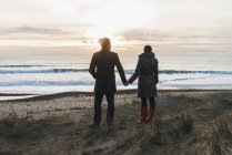 France, Bretagne, Finistère, Péninsule de Crozon, couple debout sur la côte au coucher du soleil — Photo de stock