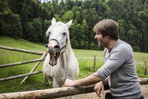 Germania, Baviera, Bad Toelz, uomo con cavallo alla recinzione — Foto stock
