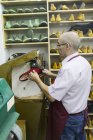 Обувщик с помощью машины в своей мастерской — стоковое фото