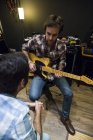 Guitar player talking to man in a recording studio — Stock Photo