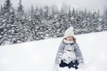 Ragazza seduta nel paesaggio invernale sulla neve — Foto stock