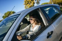 Sonriendo atractiva mujer caucásica conduciendo coche - foto de stock