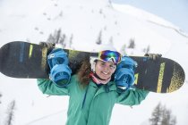 Австрія, Альтенмаркт-Заученсі, посміхається молодій жінці, що тримає сноуборд. — стокове фото