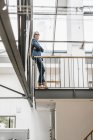 Selbstbewusste Geschäftsfrau mit langen grauen Haaren steht auf einem Dachboden — Stockfoto