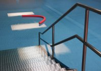 Access to indoor swimming pool with aqua noodle — Stock Photo