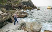 Uomo anziano pesca al mare — Foto stock
