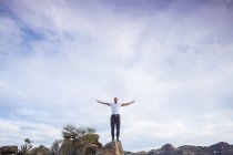 Испания, Тенерифе, человек с вытянутыми руками, стоящий на камне — стоковое фото