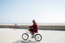 Усміхаючись велосипед їзда чоловік біля пляжу — стокове фото