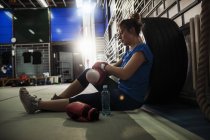 Female boxer taking a rest in the gym — Stock Photo