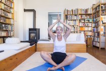 Mulher caucasiana sênior praticando ioga em casa — Fotografia de Stock