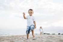 Carino caucasico fratellino e sorella divertirsi sulla spiaggia di sabbia — Foto stock