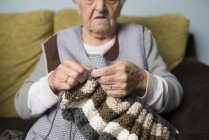 Senior woman knitting at home — Stock Photo