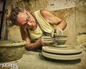 Potter en taller trabajando en jarrón - foto de stock