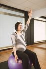 Donna incinta che fa esercizi di Pilates con palla palestra in una palestra — Foto stock