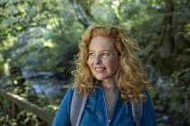 Portrait de femme souriante randonnée dans la forêt — Photo de stock