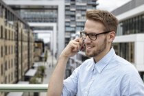 Lächelnder junger Mann mit Handy im Freien — Stockfoto