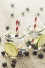 Bicchieri di acqua infusa con lime, mirtilli e cubetti di ghiaccio — Foto stock