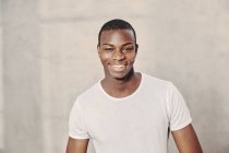 Retrato de un joven afroamericano sonriente mirando a la cámara - foto de stock