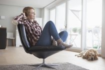 Mulher relaxante na poltrona de couro — Fotografia de Stock
