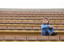 Ritratto di bambino seduto su gradini di un teatro all'aperto — Foto stock