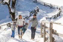 Happy family walking in snow in countryside — Stock Photo
