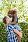 Feliz joven pareja abrazándose al aire libre - foto de stock