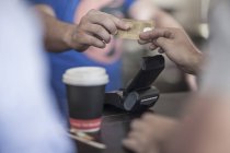 Imagem cortada do homem que paga com cartão de crédito no café — Fotografia de Stock