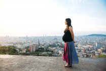 Spain, Barcelona, Pregnant woman enjoying view over city — Stock Photo